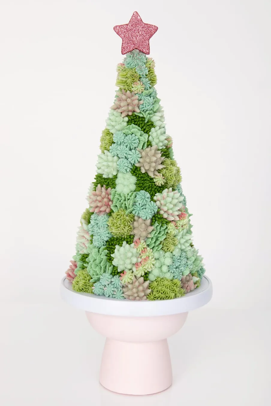 A Christmas tree of buttercream succulents with a pink star